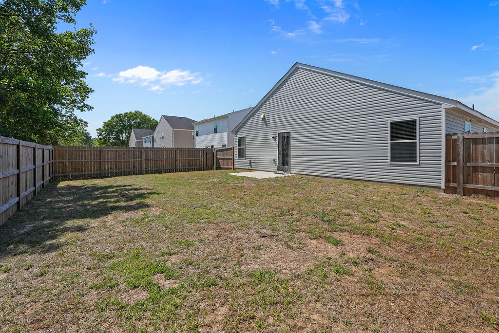 Spacious fenced backyard of 2024-built home near Fort Bragg in Raeford NC with wood privacy fence on three sides