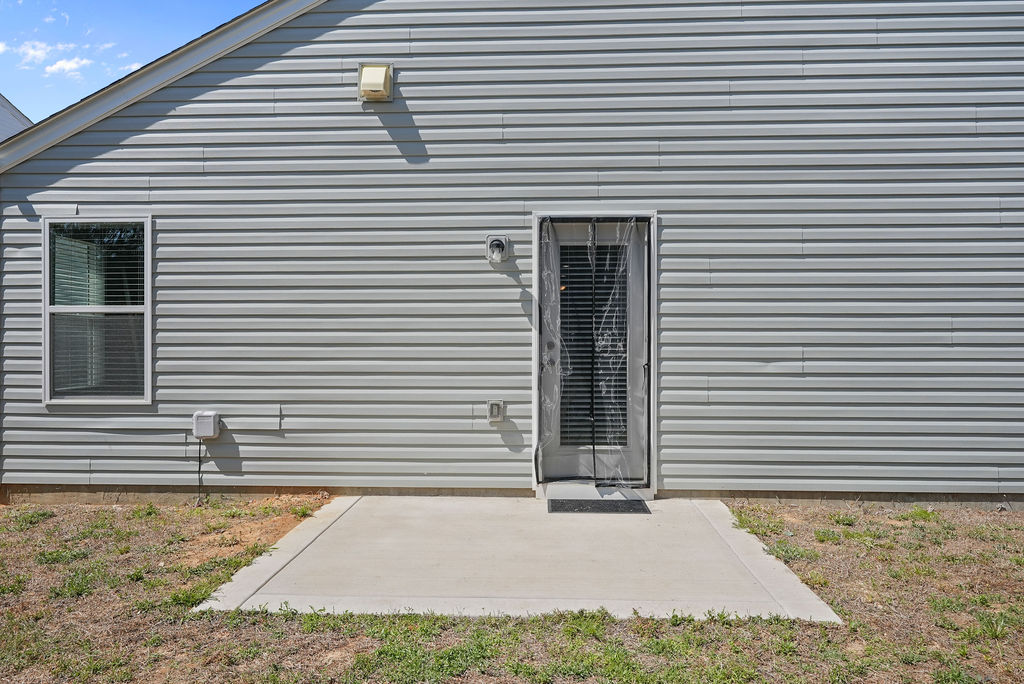 Concrete rear patio with back door entry on single-story home at 250 Melbourne Dr, Raeford NC