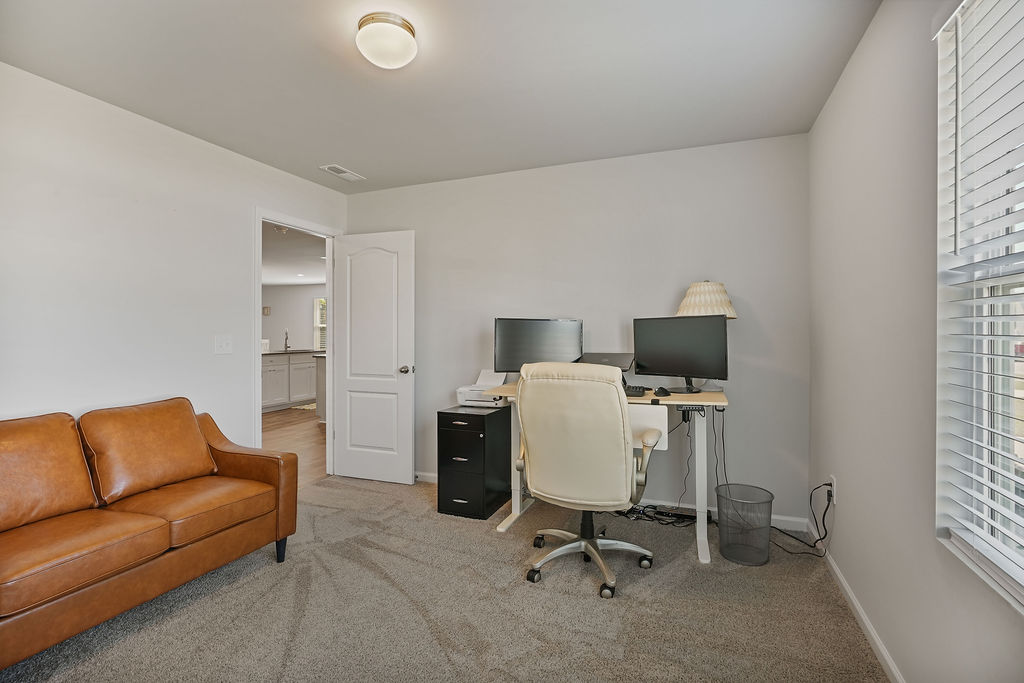 Second angle of carpeted bedroom at 250 Melbourne Dr, Raeford NC, with view through doorway to kitchen area